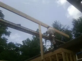 Carpenter setting a ridge beam over a new addition frame — Ice Dam Removal by Roofing Brothers in Rigby