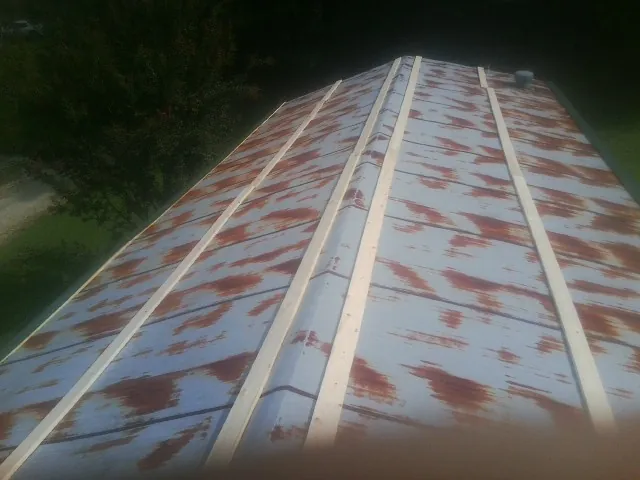 Rusted metal roof panels with new wood purlins before replacement — Storm Damage Roof Repair in Rigby by Roofing Brothers