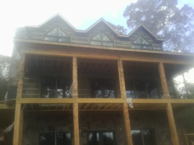 Dormers and porch framing on a large log home under construction — Roof Coating work by our crew in Rigby
